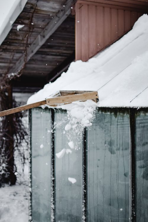 Free Snow being removed from a shed roof in snowy Estonian winter landscape. Stock Photo
