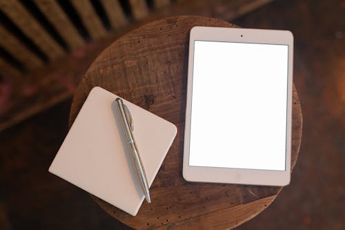 Close Up of Tablet, Notebook and Pen on Table