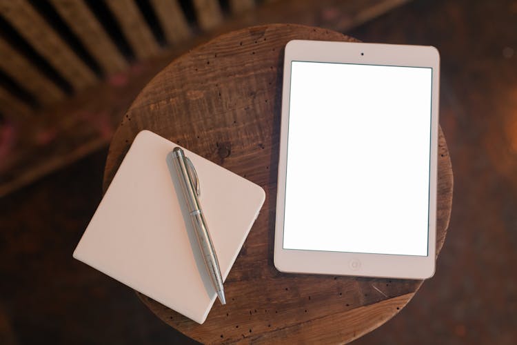 Close Up Of Tablet, Notebook And Pen On Table