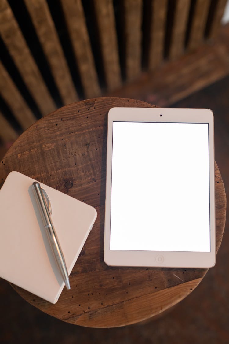 Close Up Of Tablet, Notebook And Pen On Table