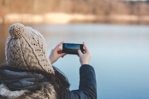 Free Back view of a woman taking photo with a smartphone Stock Photo