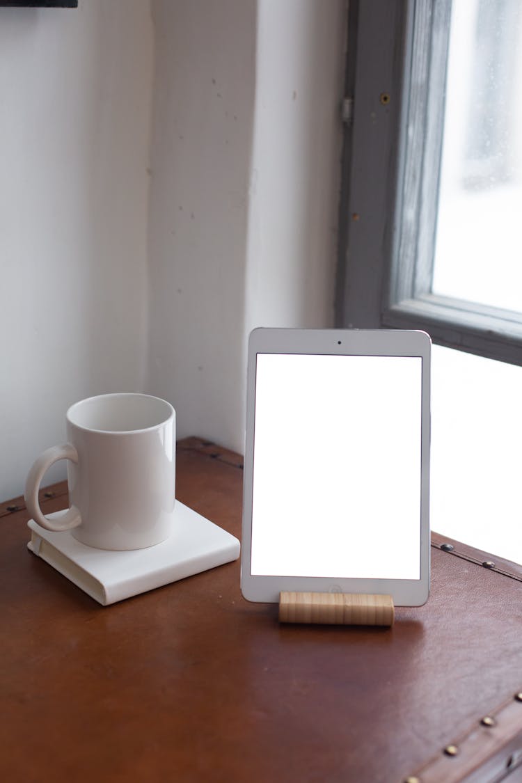 Close Up Of Tablet And Coffee On Table