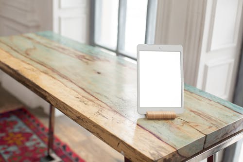 Free A Tablet with a Blank Screen on a Wooden Table Stock Photo