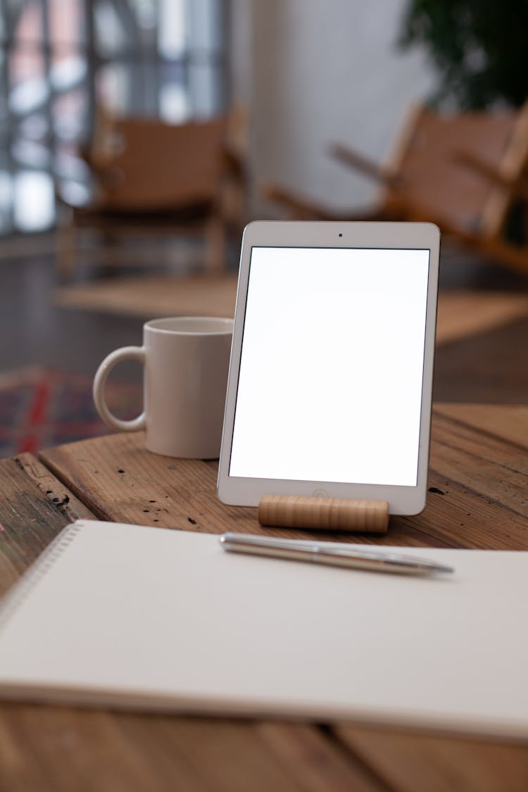 A Tablet Beside A Sketchpad