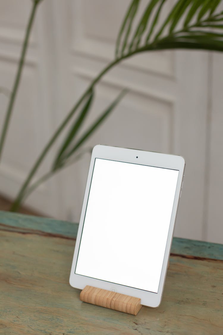 A Tablet With A Blank Screen On A Bamboo Tablet Stand
