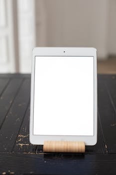 Vertical tablet mockup on a rustic wooden table ideal for app and website design presentations.