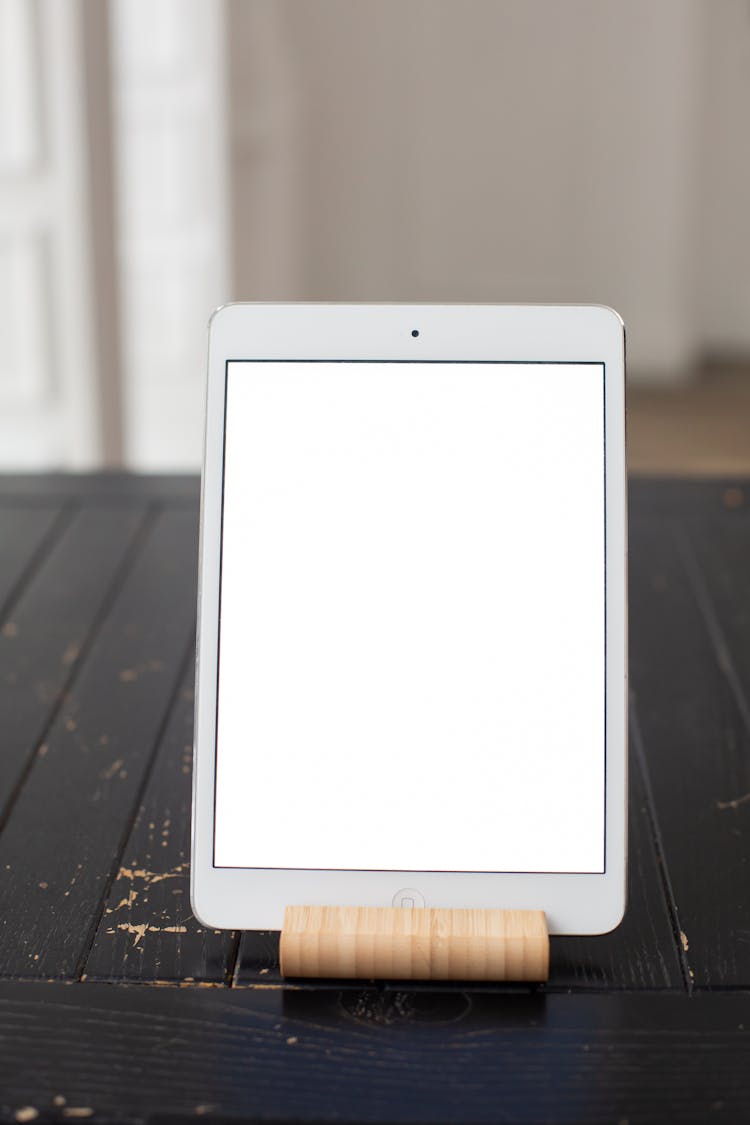 A Tablet With A Blank Screen On A Bamboo Tablet Stand
