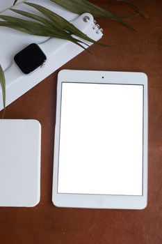 Flat lay of a tablet and smart watch on a table, with copyspace.