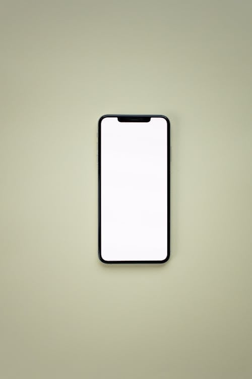 Free A Smartphone with Blank Screen Lying on a White Surface
 Stock Photo