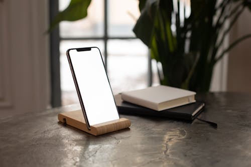 Free A Smartphone Beside the Books Stock Photo
