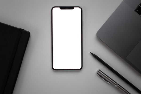 Phone and notebook on a desk — photo by Katrin Bolovtsova on Pexels
