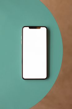 A modern smartphone with a blank screen on a teal round surface, perfect for mockups.