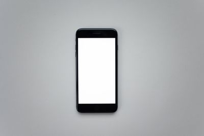 Handset with a blank screen on a grey background — photo by Katrin Bolovtsova on Pexels