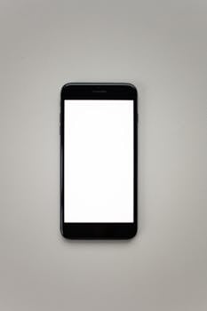 Top view of a minimalist smartphone mockup on a neutral grey surface, perfect for design presentations.