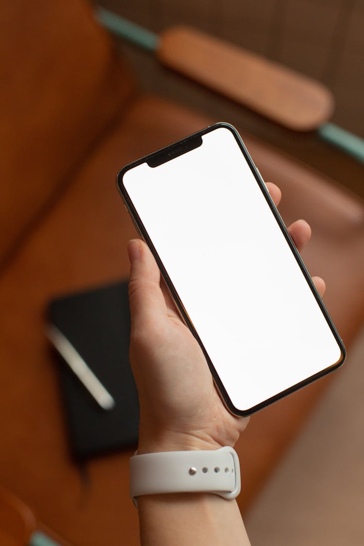 A Person Holding A Smartphone With A Blank Screen
