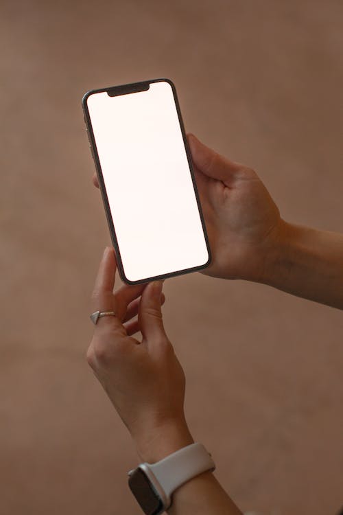 A Person Holding a Smartphone with a Blank Screen
