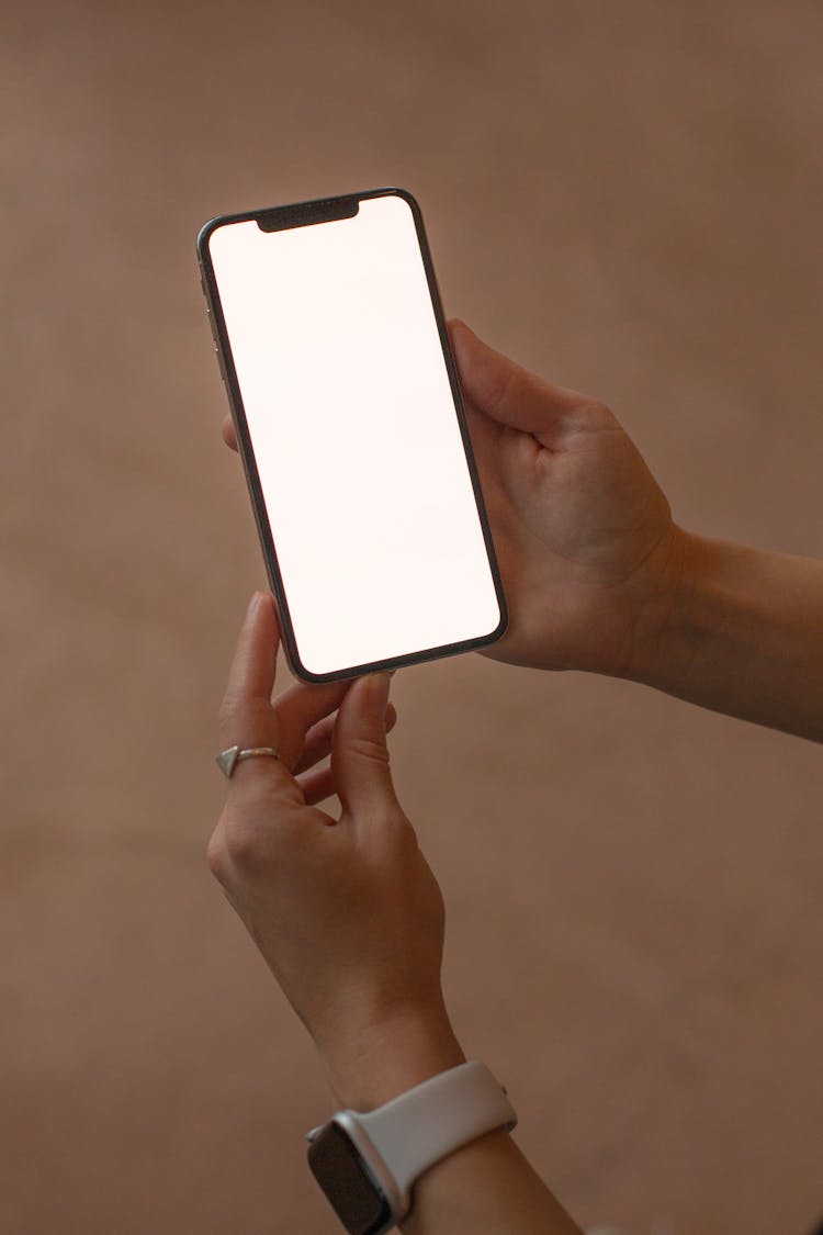 A Person Holding A Smartphone With A Blank Screen
