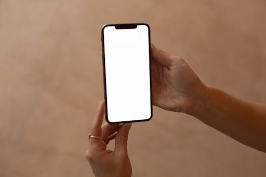 Hands holding a smartphone with a blank screen, perfect for mockup and design presentations.
