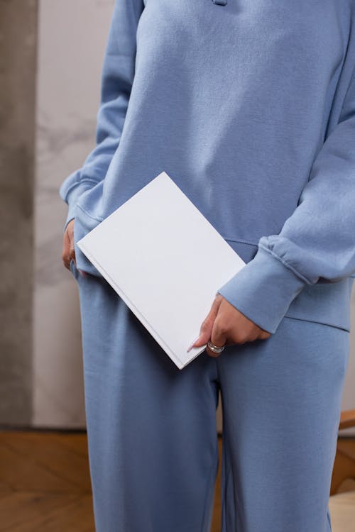 Free Woman in activewear holding blank notebook Stock Photo