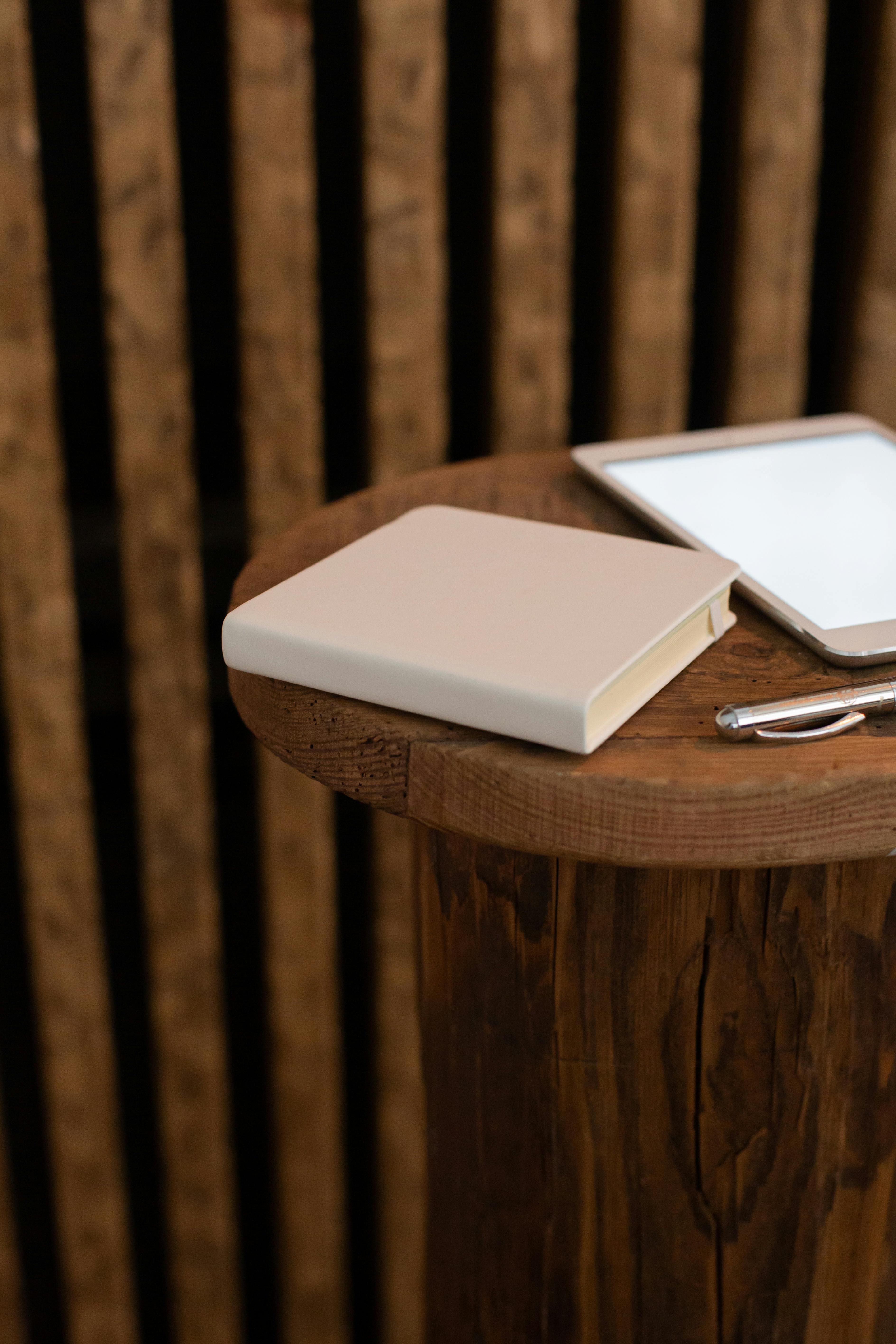 notebook with pen and tablet on table