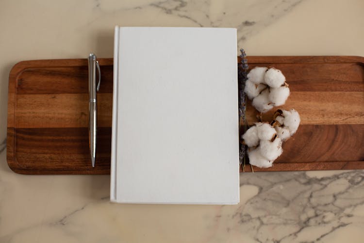 White Notebook With Pen And Cotton Flowers On Tray