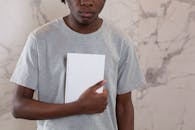 Crop black man with mock up notebook