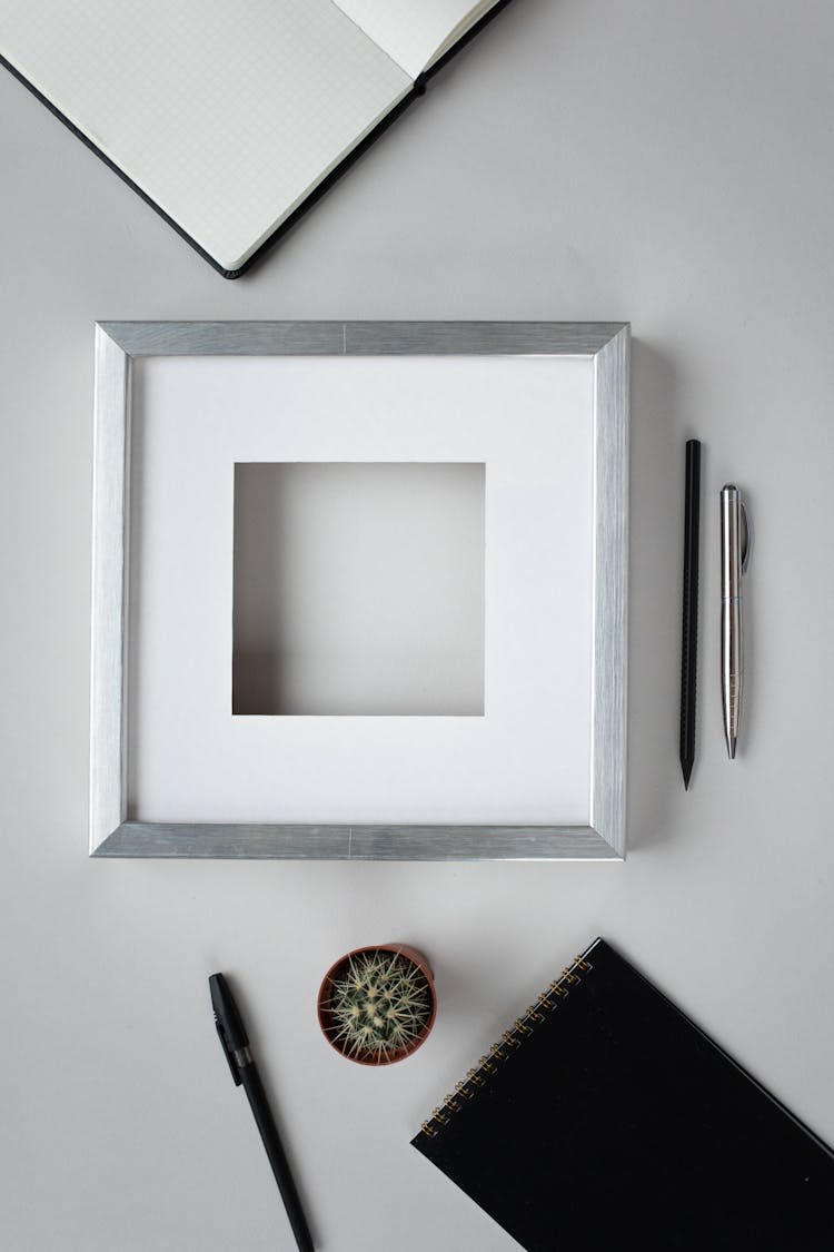 Blank Frame With Stationery On Table