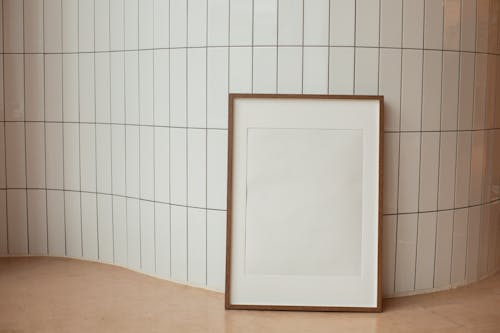 Rectangular empty photo frame against tiled wall