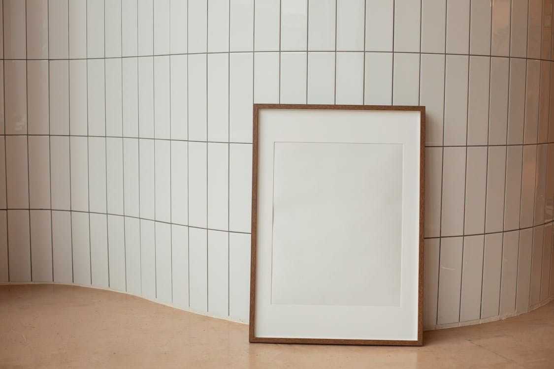 Rectangular empty photo frame against tiled wall