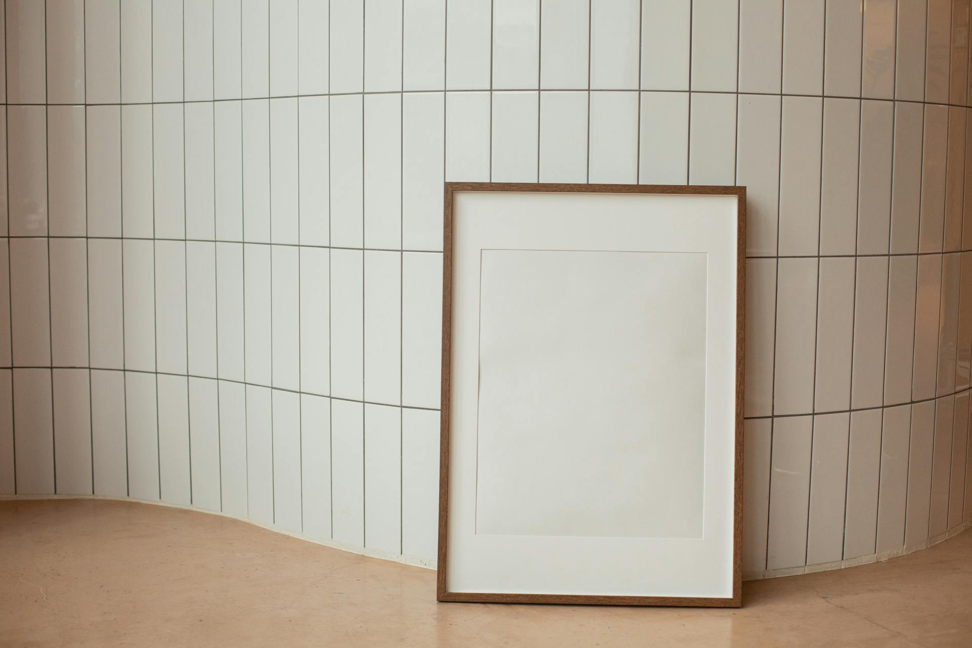 Rectangular empty photo frame against tiled wall