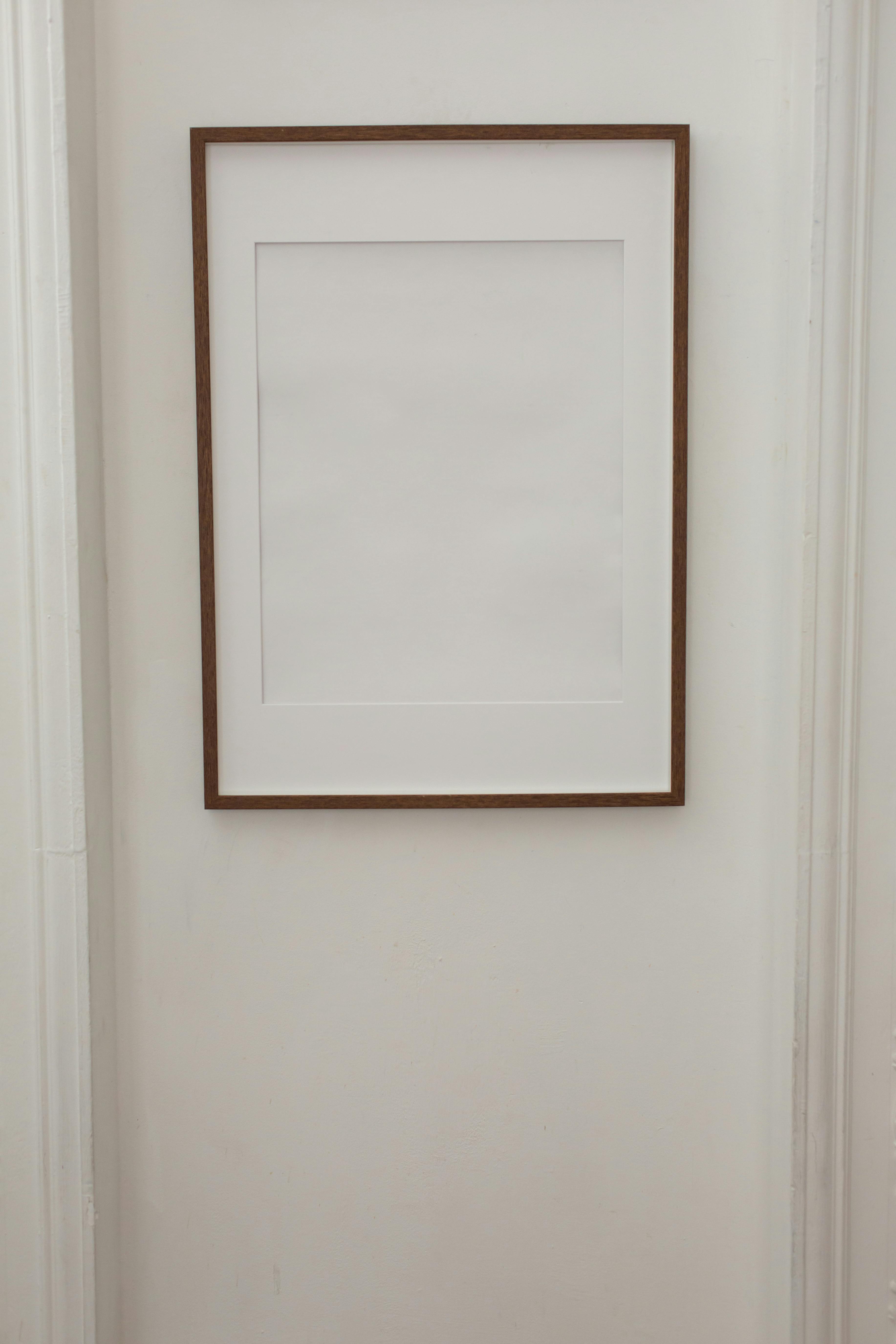 blank simple frame hanging on white wall of apartment