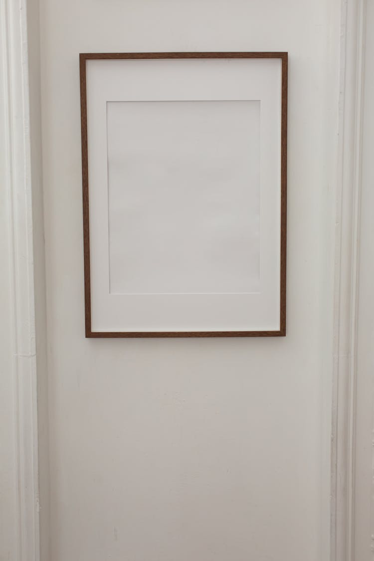 Blank Simple Frame Hanging On White Wall Of Apartment