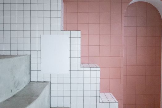 White blank paint hanging on tile white wall near arched entrance in room with minimalistic design