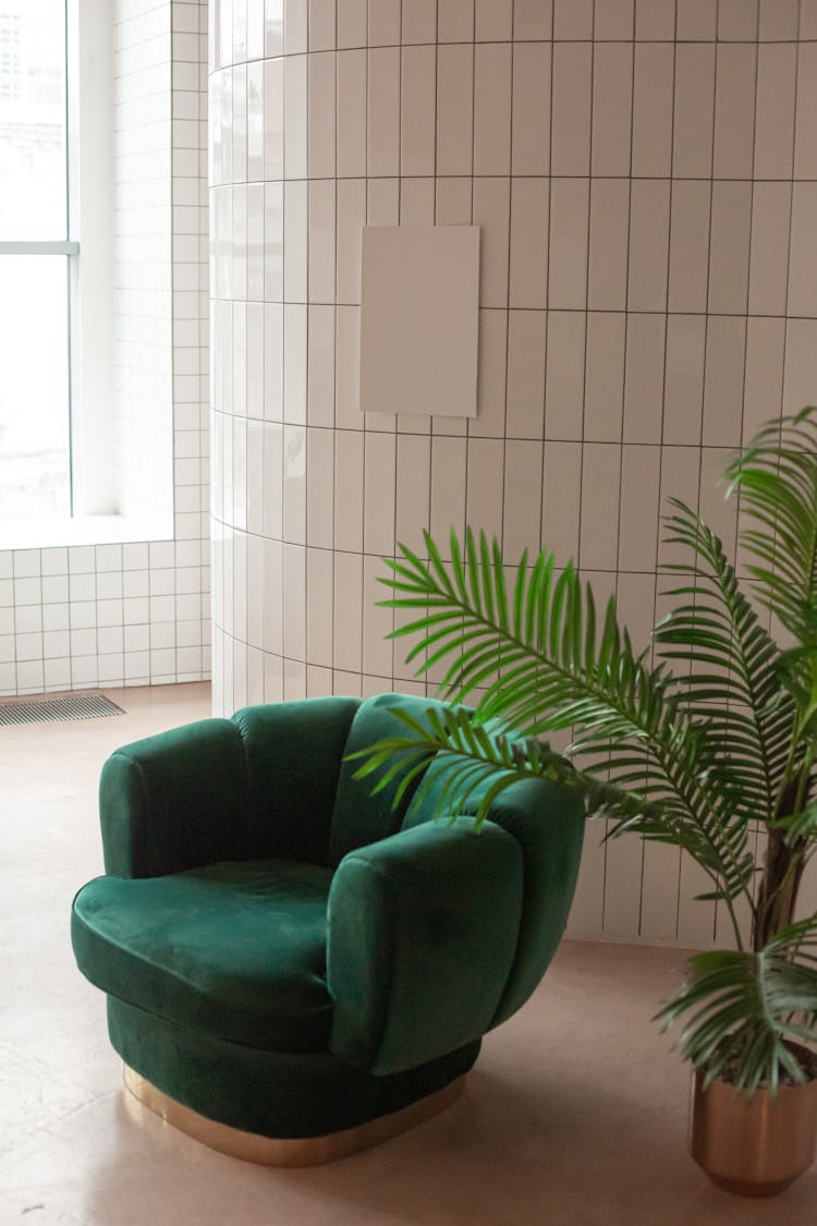 Armchair Near Potted Plant And White Board On Wall