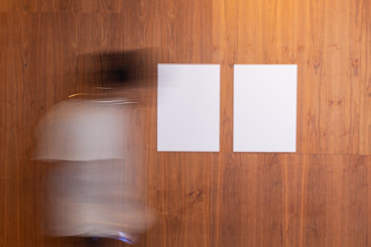 Faceless Person Walking Near Blank Posters