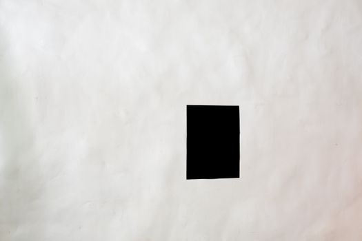 Creative black rectangular mock up poster with copy space attached to white wall in light room of modern spacious studio