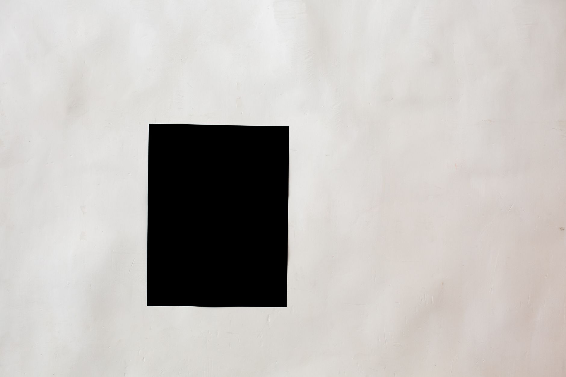 Creative black mock up rectangular paper sheet with copy space attached on white wall in light room of modern studio