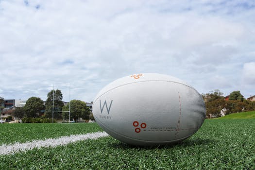 A detailed shot of a rugby ball on a green sports field, perfect for sports equipment themes.