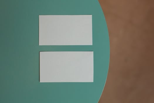 Top view of creative white mock up business cards with copy space placed on round green table in light room