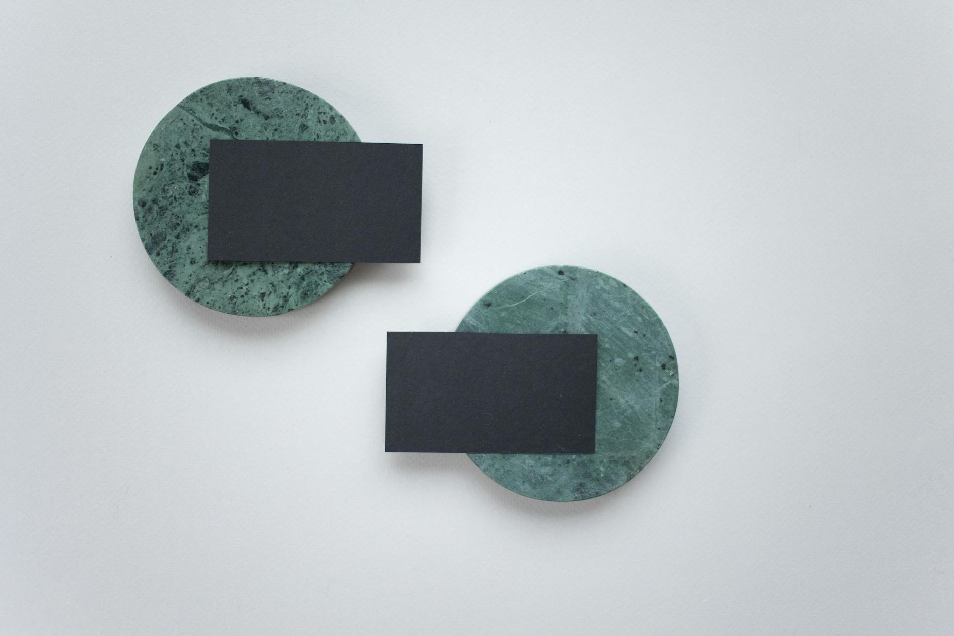 A minimalist business card design displayed on round marble coasters, perfect for branding presentations.