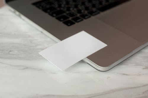 White mock up business cards with copy space placed on modern opened gray netbook on marble table in creative workplace