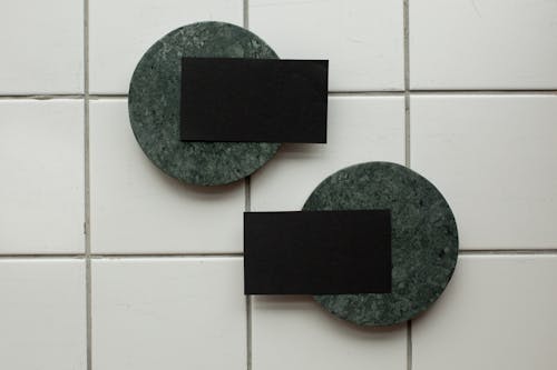 Free Top view of black mock up business cards on round green boards placed on floor in light room of studio Stock Photo