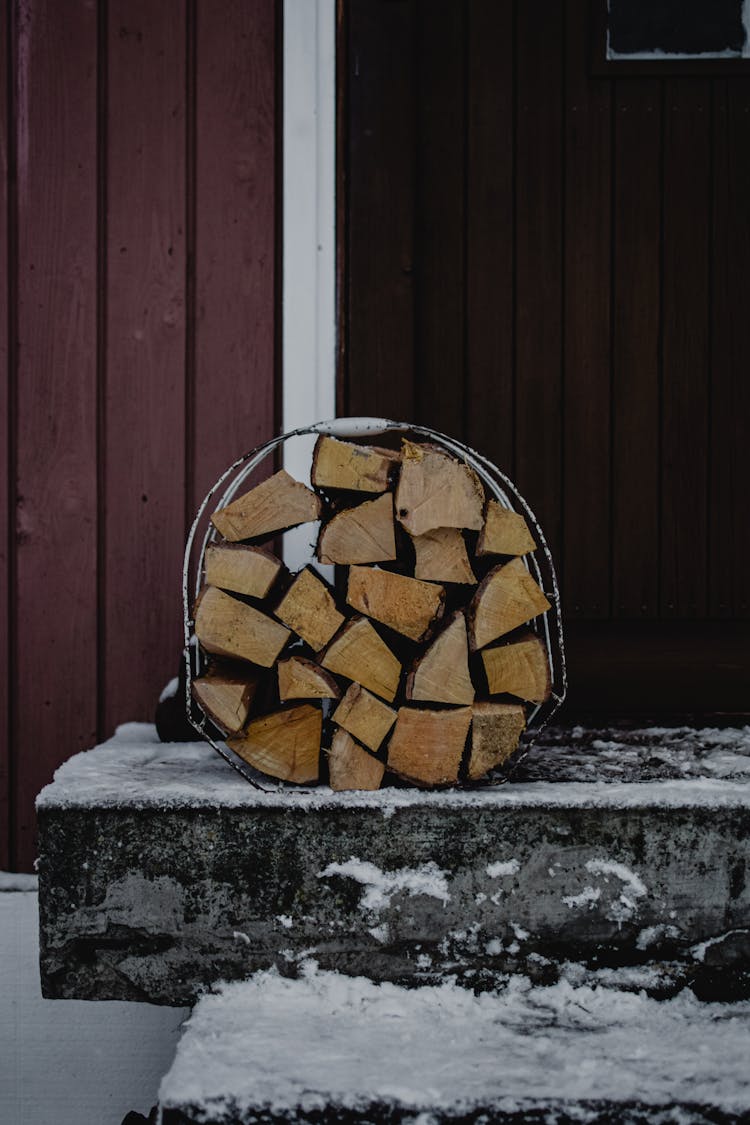 A Bundle Of Chopped Wood On A Porch 