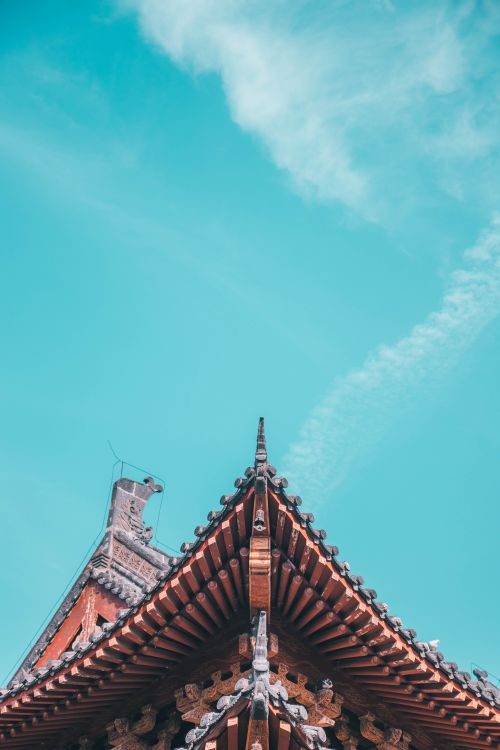 Free Low angle view of a traditional Asian temple roof against a clear blue sky. Stock Photo