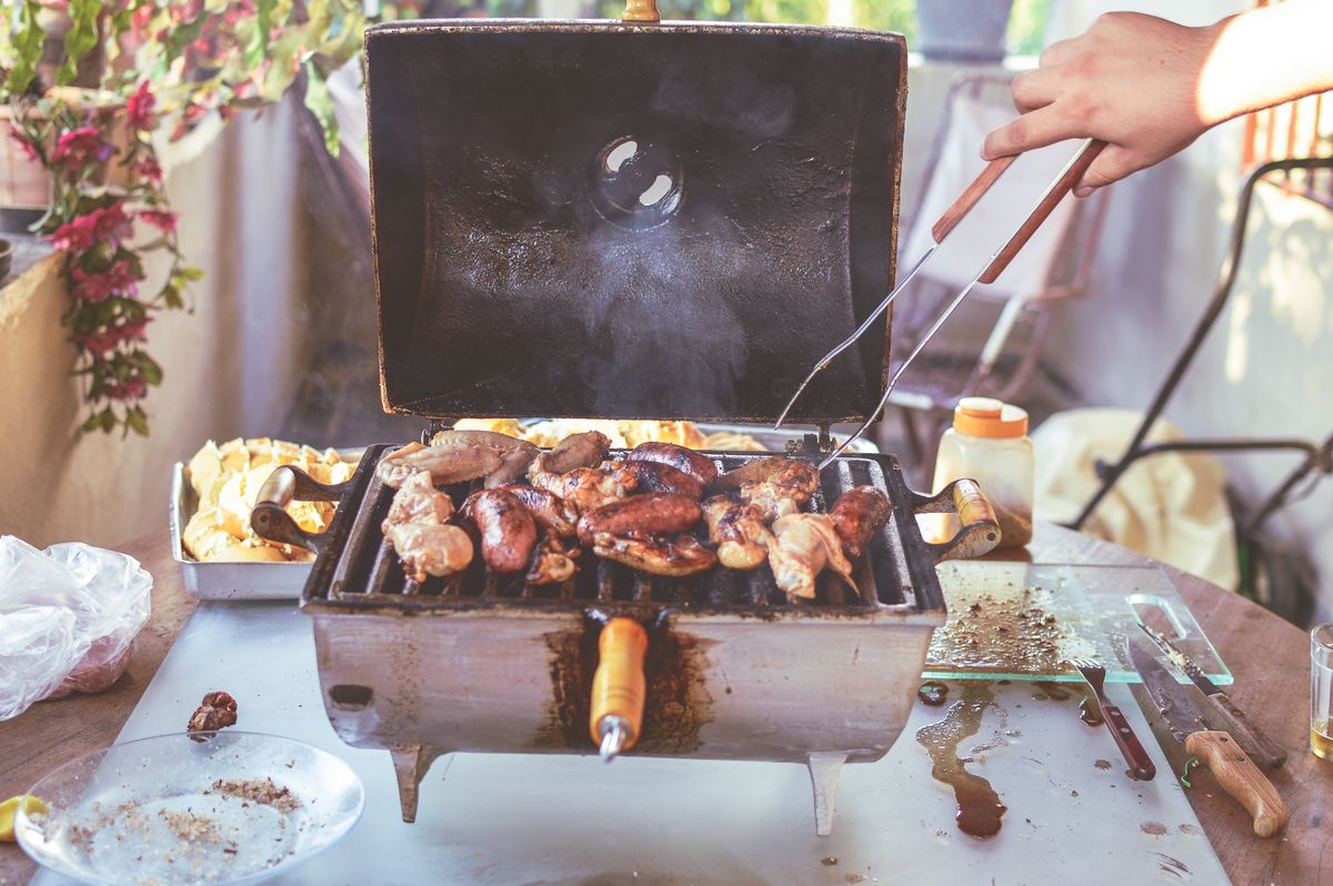 Grilling delicious barbecue meats during a sunny summer afternoon gathering
