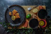 Black Round Plate With Food and Stainless Steel Fork
