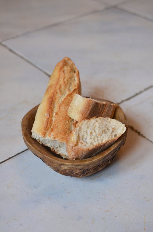 Fresh cut bread in wooden bowl