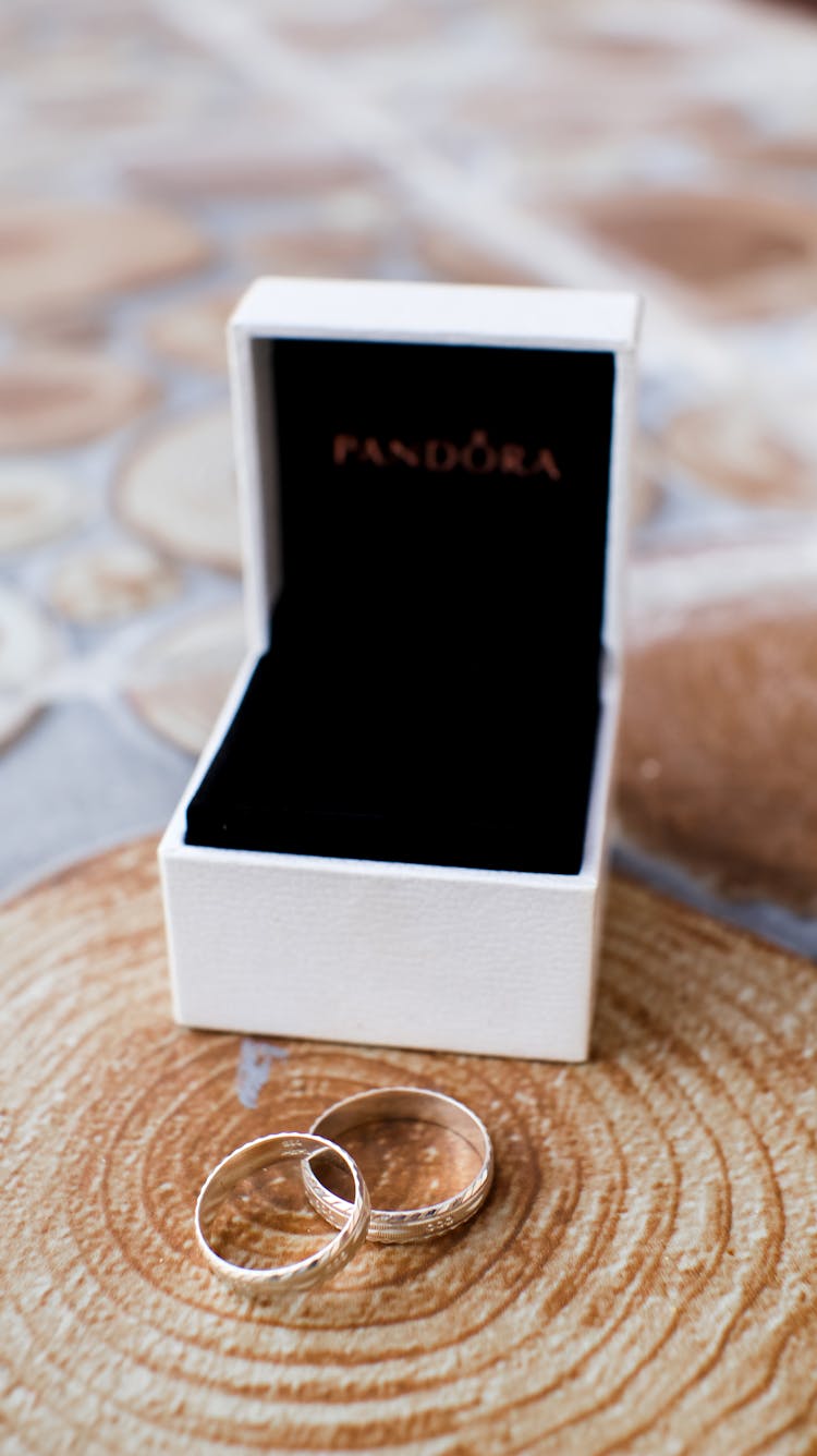 Wedding Golden Rings Placed On Wooden Board Near Box