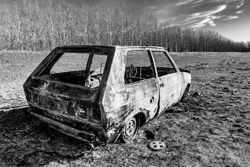 Grayscale Photo of an Abandoned Car