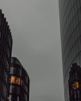 From below of contemporary skyscrapers located in city against cloudy sky in evening time